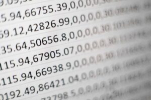 Close-up of a computer screen displaying rows of numerical data. The numbers, including decimals and commas, are organized in lines and columns, emphasizing data analysis or financial information. The image is slightly blurred, focusing on the digital presentation.
