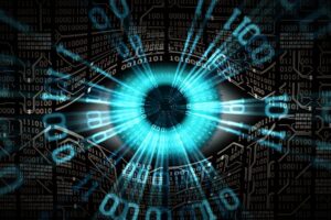 A digital eye formed by radiant blue lines and binary code on a dark background. The eye's iris is a glowing blue circle, with surrounding numeric patterns resembling the structure of an eye. The image conveys a fusion of technology and vision.